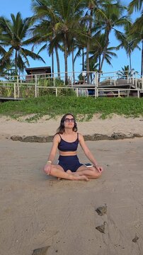Mulher meditando pela manha na praia 