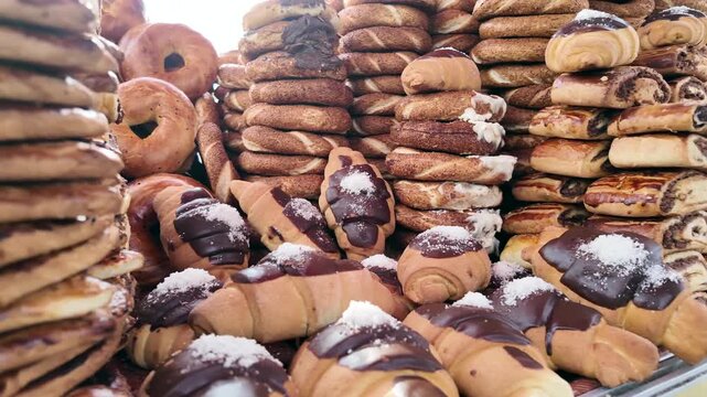 Assortment of fresh baked goods including croissants bagels and pastries presented at market stall