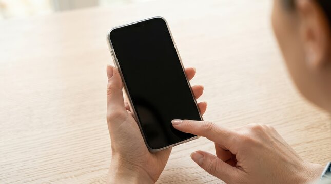 Hand holding smartphone with blank screen and finger touching display