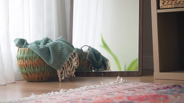 Cozy interior details with woven basket mirror reflection and patterned rug