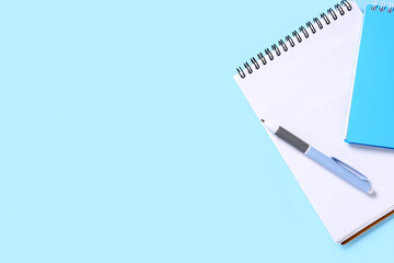 Fototapeta premium Notebooks with pen on blue background