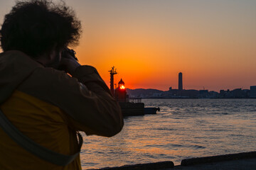 Fototapeta premium 港の夕日を撮影する旅人20260321