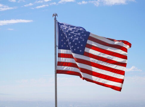 Flag of the United States of America waving on top of Cahuenga Peak at Wisdom Tree during a summer season in Los Angeles, California, USA