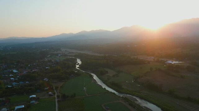 Aerial 4K of a peaceful river winding through the valley at sunset, Pai, Thailand