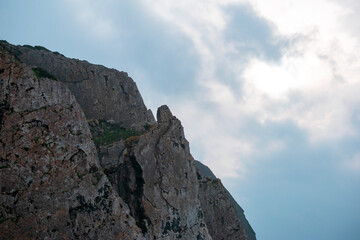 Fototapeta premium Rugged Cliff Face Under Cloudy Sky