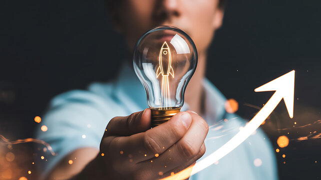 A hand holds a lightbulb containing a rocket symbolizing innovation and upward trajectory high quality