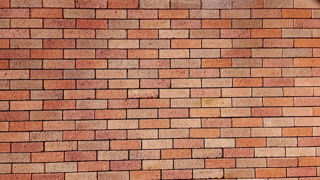 High-quality texture of a classic red brick wall. The masonry shows variations in red, brown, and tan colors with dark mortar lines. Ideal for architectural backgrounds, grunge designs, and patterns.