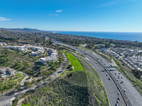Aerial view over San Juan Capistrano, California, featuring the historic mission, library, sports courts, and an Amtrak train pulling into the downtown station. High quality 4k footage
