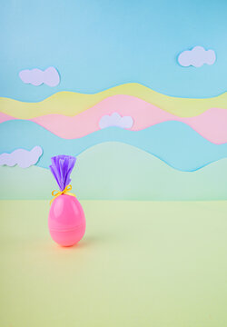Cute pink easter egg with bow and wrapping on soft pastel background with clouds spring holiday minimal banner with copy space.
