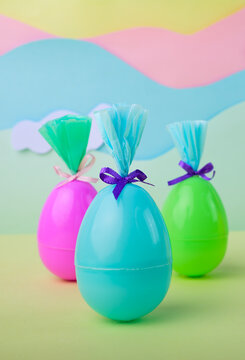 Colorful easter eggs with gift wrapping on pastel background with clouds and rainbow decoration spring holiday concept minimal studio scene.