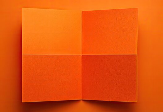A vibrant, close-up shot of an orange paper folded in quarters, creating four squares