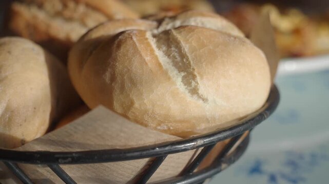 Freshly baked kaiser rolls in a basket with a soft natural light