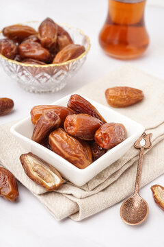 Bowl with dried dates on light background