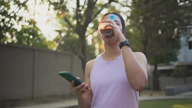 Young active woman drink whey protein shake bottle eating diet food using phone calorie AI plan app after workout health care asia people happy relax anti aging life weight loss public green park walk