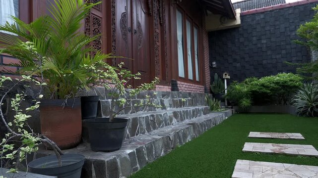 Low angle footage of green front garden view with Indonesia traditional wooden house, its called joglo house
