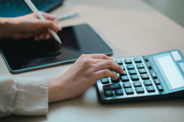 businesswoman using calculator on desk, representing digital finance, accounting, online banking, budgeting, tax management and modern fintech workflow in office