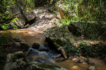 A small, serene waterfall cascades over dark, glistening rocks in a continuous, gentle flow, capturing the pure, raw beauty of nature in motion in Brazil. © AlfRibeiro