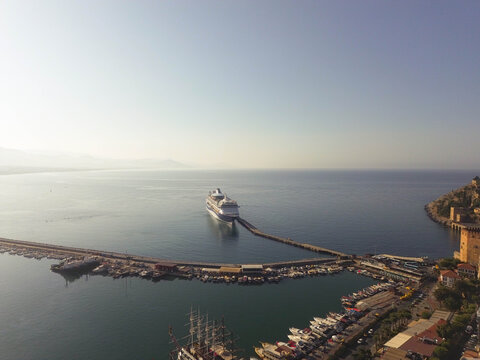 Aerial drone video of Alanya Harbor in Antalya, Turkey, featuring multiple cruise ships docked at the port.