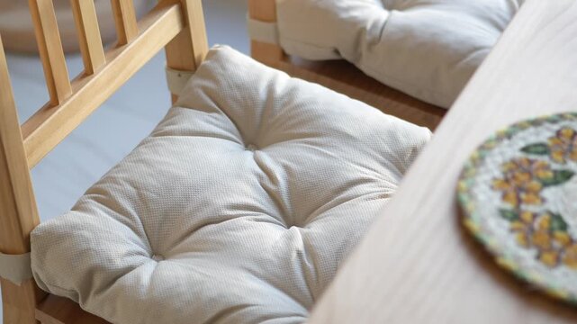 Cushioned chairs and a round mat on a wooden table