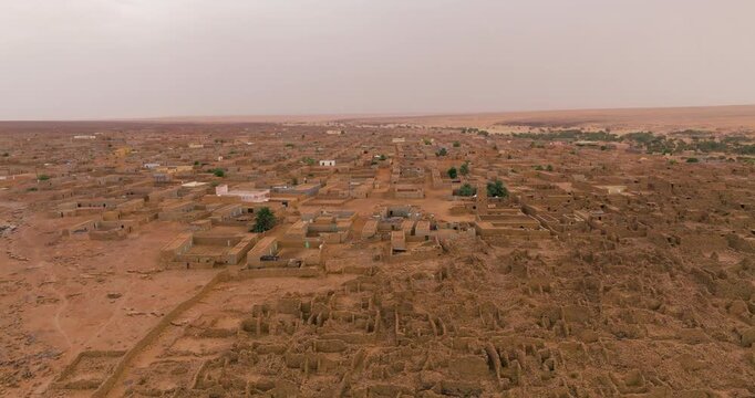 Ancient Stone Buildings And Desert Architecture On Arid Dunes Of Ouadane In Mauritania. orbiting aerial shot