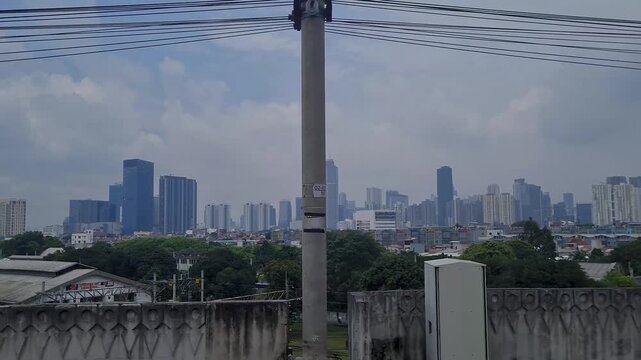 View of Jakarta City Skyline and Skyscrapers from Inside a Moving Commuter Line Train Indonesia
