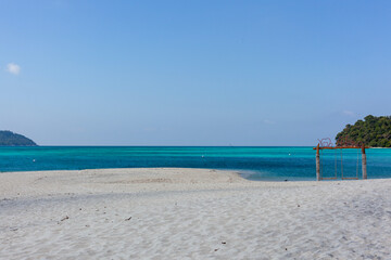 Obraz premium Tropical beach at Koh Adang with clear blue water. White sand shoreline in Tarutao National Park, Thailand. Secluded island setting with turquoise sea.