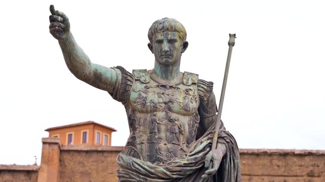 Ancient bronze statue of Augustus, the first Roman emperor, with arm raised and staff