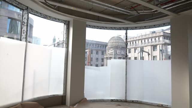 Curved interior with large windows and view of dome building in D&uuml;sseldorf, modern architecture space in unfinished building during renovation and development phase