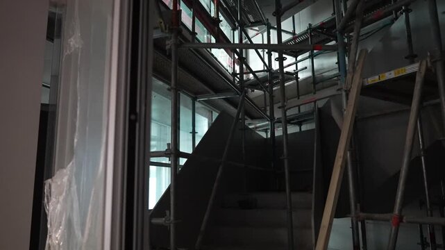 Interior construction scaffolding structure inside unfinished building, industrial framework during renovation and fit out phase, modern architecture and structural development indoors