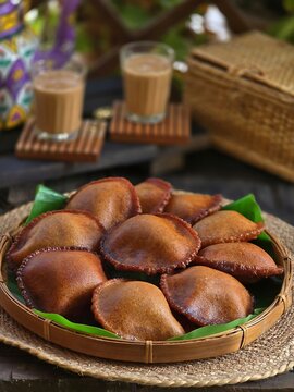 Delicious traditional Indian Patishapta Pitha sweets are artfully arranged on a banana leaf inside a woven basket.