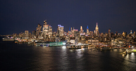 Fototapeta premium New York cityscape waterfront. NYC panoramic view of Lower Manhattan skyline. NewYork big American City. New York City at night. New York City aerial skyline. New York City downtown at night.