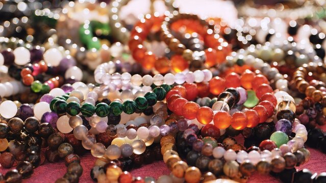 Assorted natural stone bead bracelets displayed, showing vibrant colors and textures