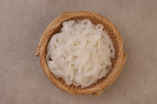 Kwetiau or kway teow or kuey teow noodles are flat, wide rice noodles made from rice flour and water, known for their smooth, slightly chewy texture and glossy appearance.