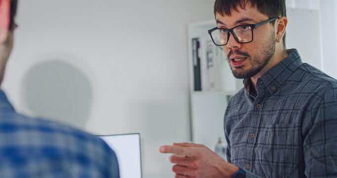 Team adult male engineer collaborate on robotic hand project using AI code solutions machine learning at tech workspace. Artificial intelligence interface, collaboration support prototype development.