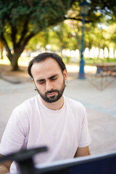 Artist drawing caricatures of people in a park with a relaxed expression