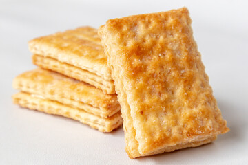 Fototapeta premium Golden puff pastry sprinkled with sugar isolated on white background. Pastry cookie in square shape. Clipping Path