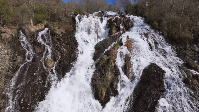 Waterfall Cascading Down A Rocky Surface At Furelos River In Toques, A Coru&ntilde;a Province Of Galicia, Spain. Aerial Shot
