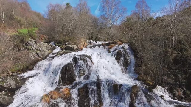 Waterfall Cascading Down A Rocky Slope At Furelos River In Toques, Melide, A Coruna, Galicia, Spain. Aerial Pullback Shot