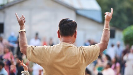Man raising arms during Ganesh Chaturthi festival celebration in a crowd