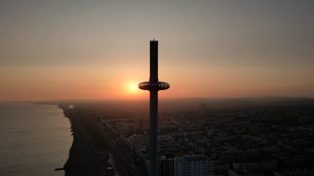 Wide Sunset of Brighton i360 with Golden Sun City Skyline and Coastline in Brighton England, Aerial Drone