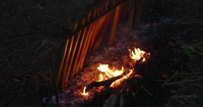 Experience traditional method of cooking sticky rice in bamboo Khao Lam over an open fire at night.