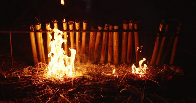 Cooking khao lam sticky rice in bamboo over fire traditional thai cuisine outdoor gathering