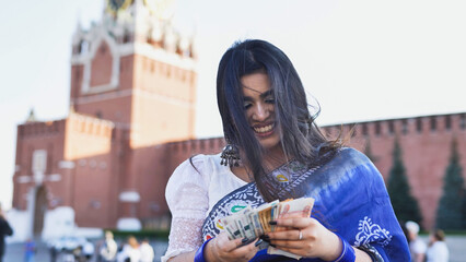 Young Indian woman counting money in Moscow