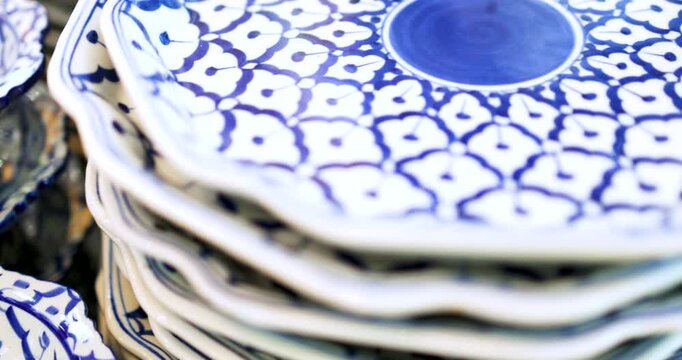 Stacked blue and white Thai patterned ceramic plates. Traditional Asian design ideal for food, close-up. home decoration and cultural lifestyle visuals