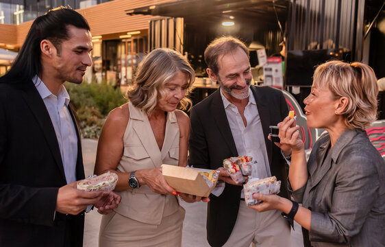 Business colleagues enjoying street food from a food truck