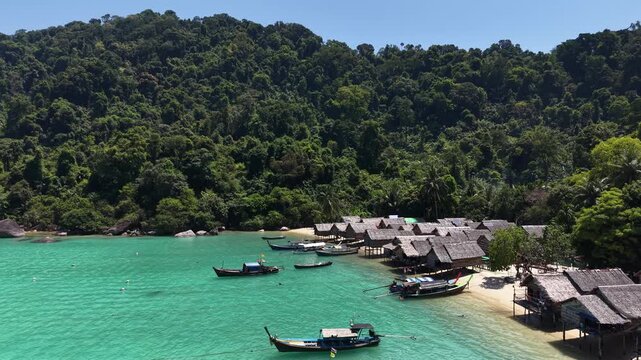Aerial view of Ko Surin Marine National Park. Traditional long-tail boats and houses of Moken tribe Village or Sea Gypsies and tropical waters of Surin Islands in Thailand, Phang Nga.
