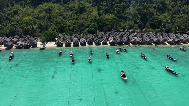 Aerial view of Ko Surin Marine National Park. Traditional long-tail boats and houses of Moken tribe Village or Sea Gypsies and tropical waters of Surin Islands in Thailand, Phang Nga.
