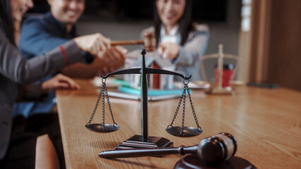 Real estate auction concept: gavel striking on model house atop laptop, with negotiators and scales...