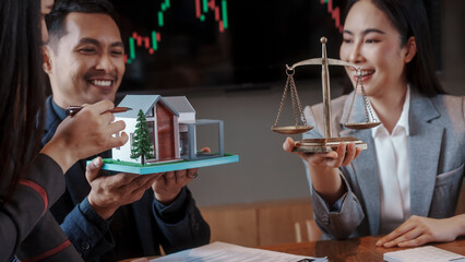 Real estate auction concept: gavel striking on model house atop laptop, with negotiators and scales...