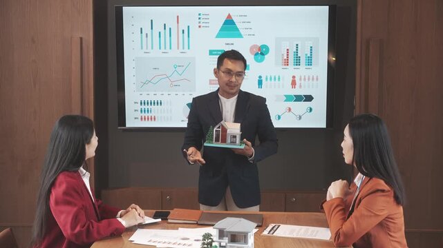 Business presentation with charts and architectural model in meeting